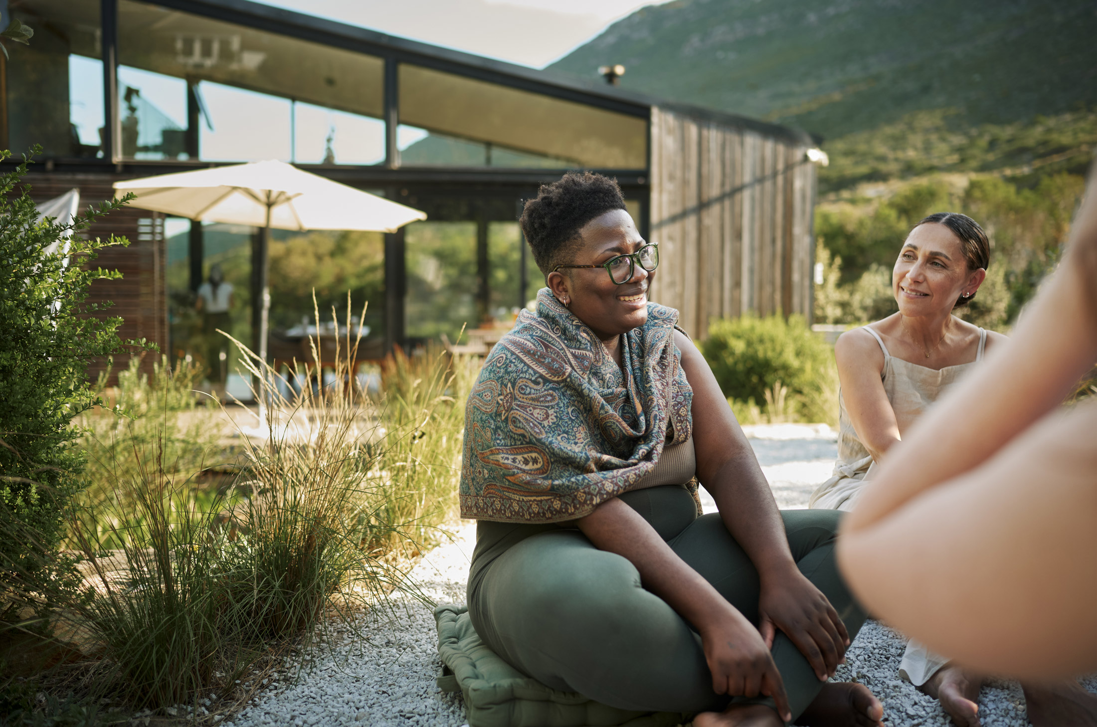 women sitting outside house talking